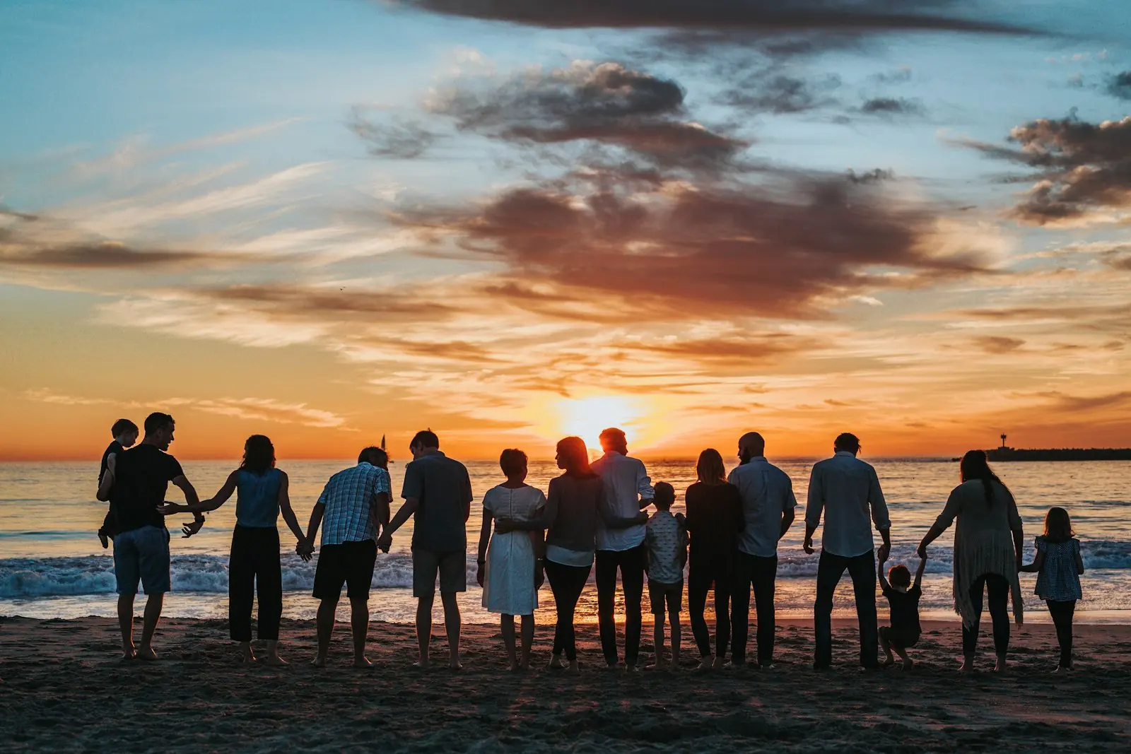 A family together on a beach at sunset