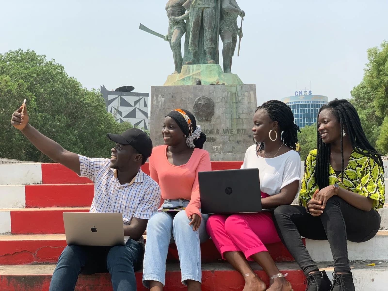 Students with their laptops on the steps of a city square